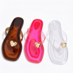 Display of Pink, Brown and Clear color of 3 Jelly Flat Trinidad and Tobago sandals on a white floor